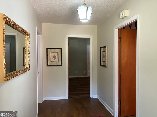 a view of a hallway with wooden floor and closet