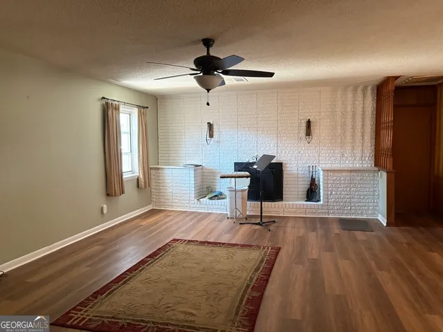a view of a livingroom with wooden floor and a ceiling fan