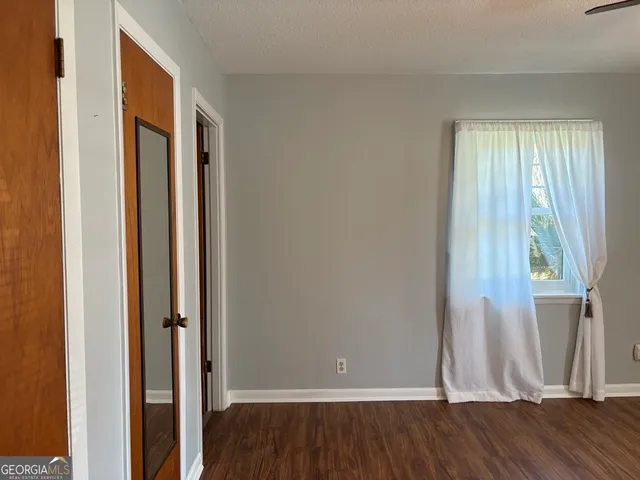 an empty room with wooden floor and a window