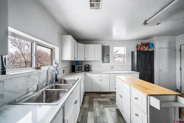 a kitchen with granite countertop a sink and white cabinets