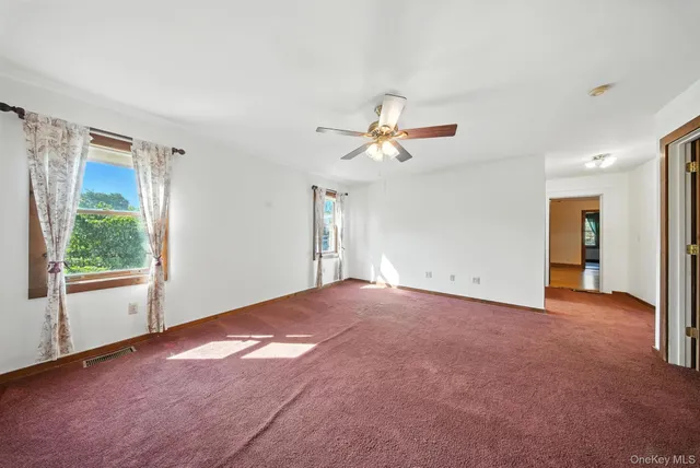 a view of a livingroom with a ceiling fan and window