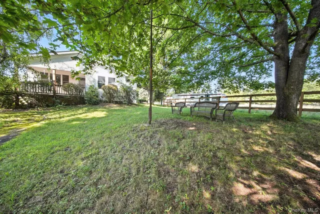 a view of a yard with swimming pool and trees in the background