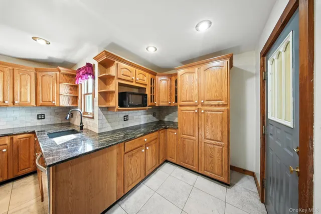 a kitchen with stainless steel appliances granite countertop a sink and a refrigerator