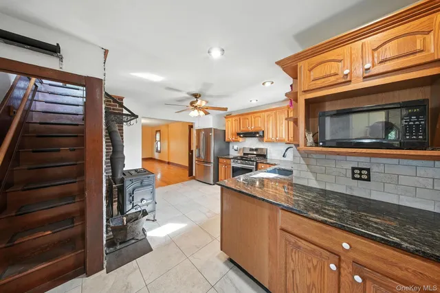 a kitchen with stainless steel appliances granite countertop a sink and a microwave