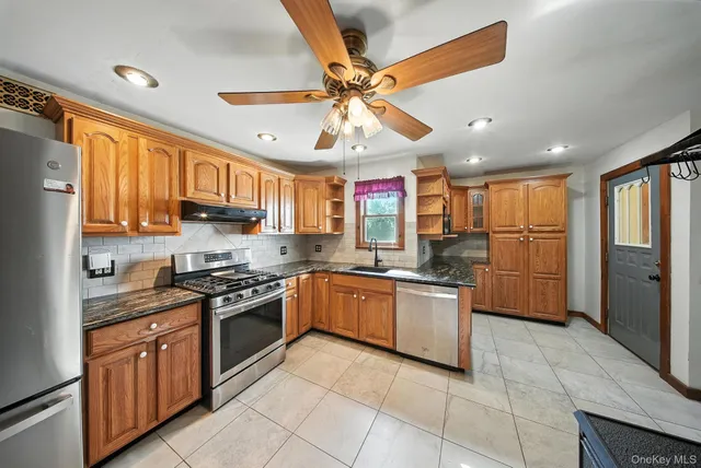 a kitchen with stainless steel appliances granite countertop a sink and cabinets