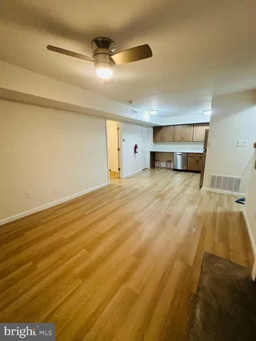 a view of a livingroom with wooden floor and a ceiling fan