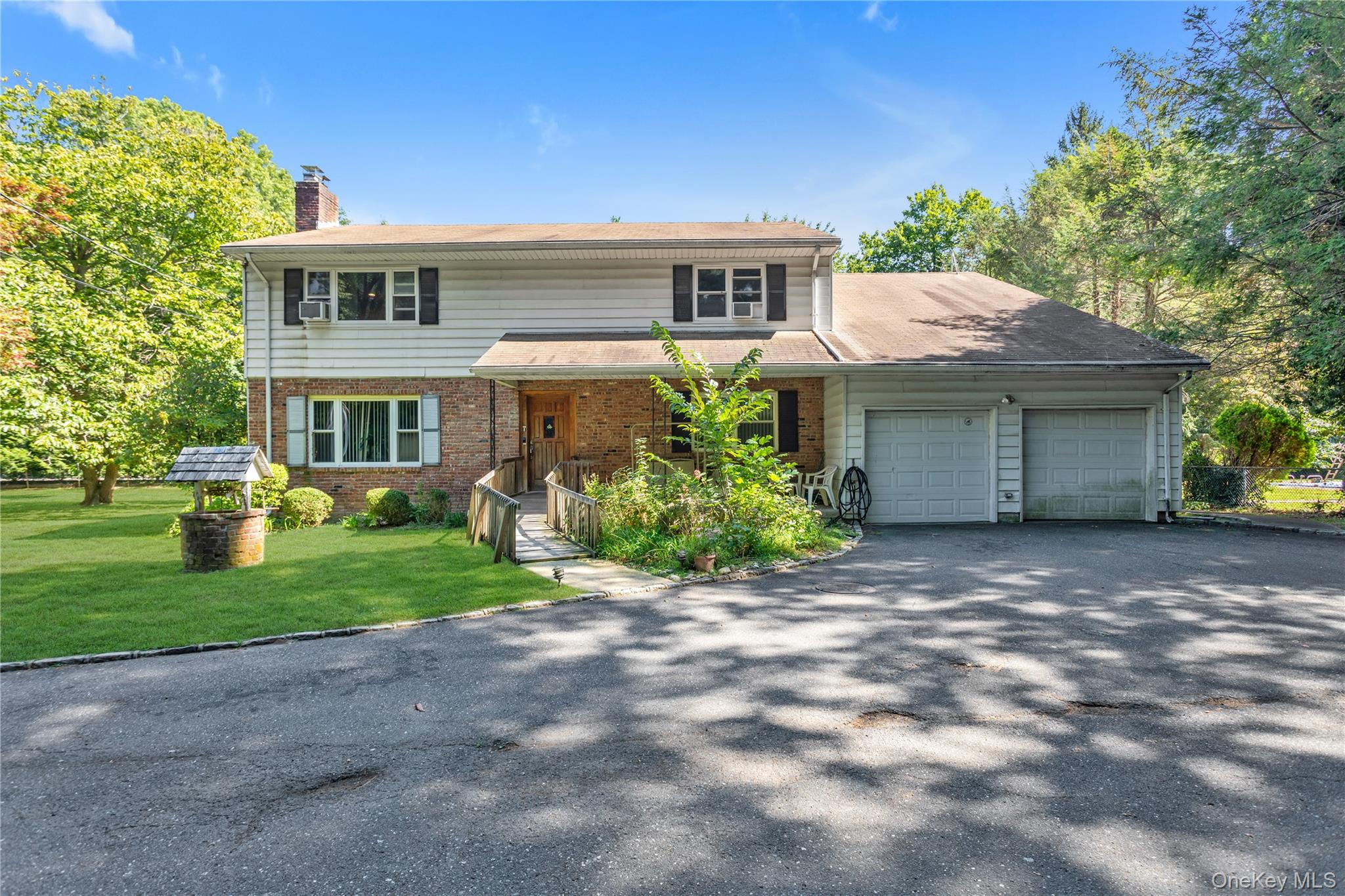 270 Frost Pond Road Glen Head, NY 11545 - Photo 2 of 19 Traditional home featuring asphalt driveway, brick siding, a porch, a garage, and a chimney