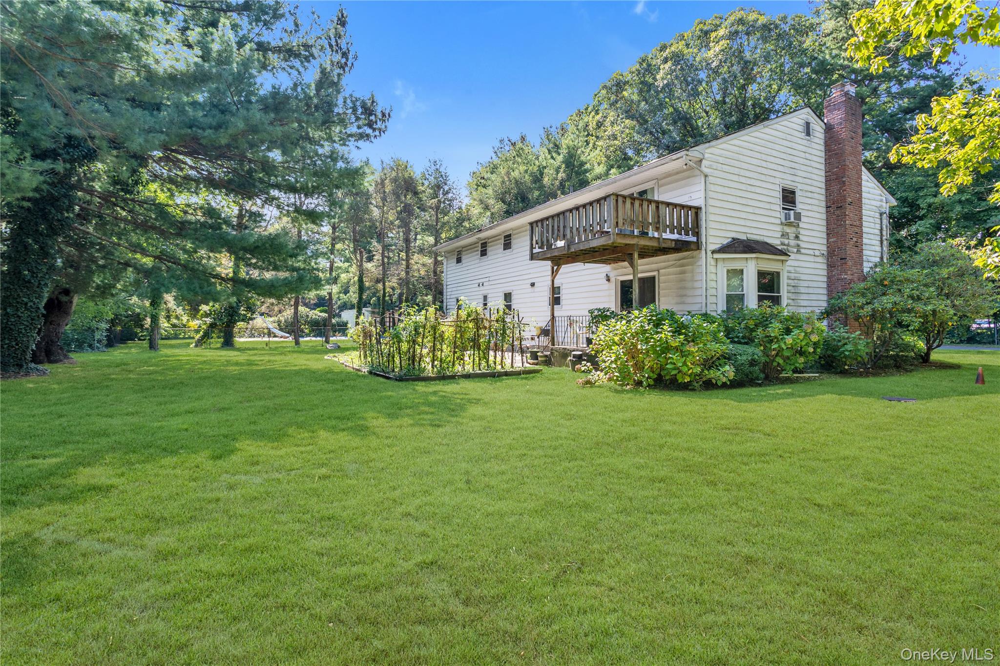 270 Frost Pond Road Glen Head, NY 11545 - Photo 4 of 19 Rear view of house featuring a an elevated deck and patio underneath