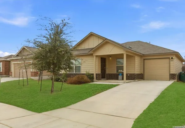 a front view of a house with a yard and trees