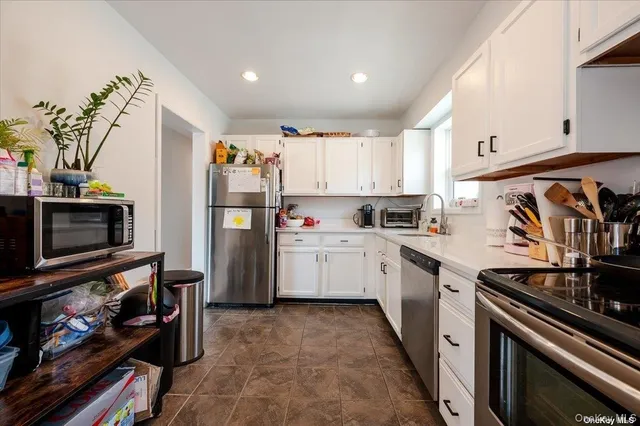 a kitchen with stainless steel appliances a stove refrigerator sink and cabinets