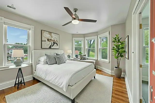 a bedroom with a bed and a large window