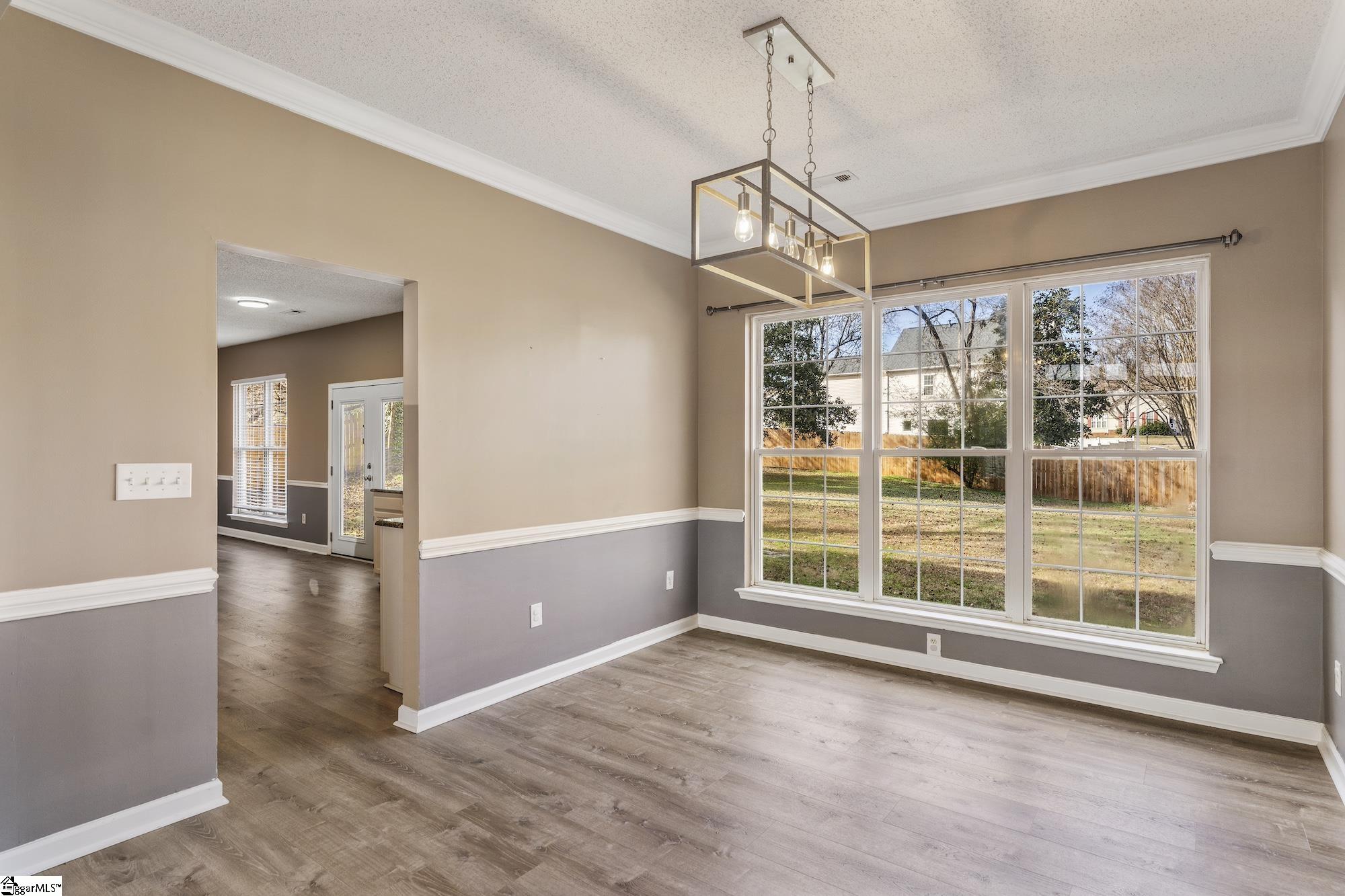 Dining room with large windows and access to kitchen