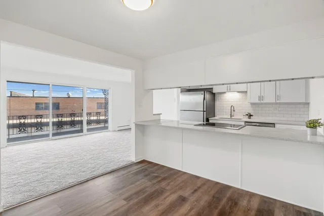a kitchen with stainless steel appliances a sink stove and wooden floor