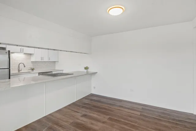 a kitchen with a sink cabinets and wooden floor
