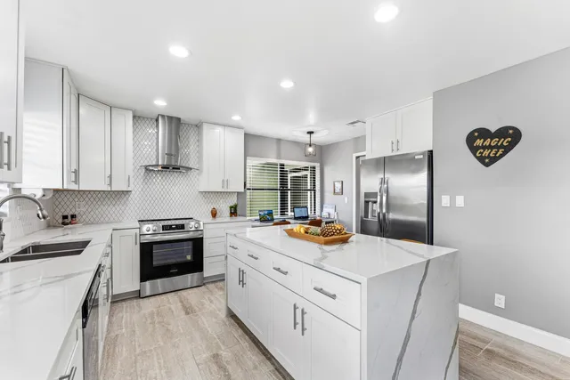 a kitchen with stainless steel appliances a refrigerator sink and stove