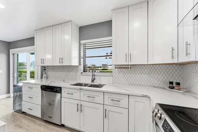 a kitchen with cabinets appliances a sink and a window