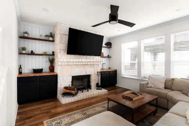 a living room with furniture a fireplace and flat screen tv
