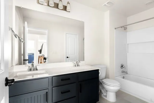 a bathroom with a double vanity sink toilet and shower
