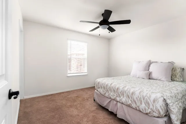 a bedroom with a bed and a ceiling fan