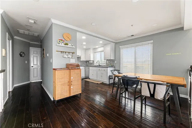 a kitchen with stainless steel appliances wooden floors and white cabinets