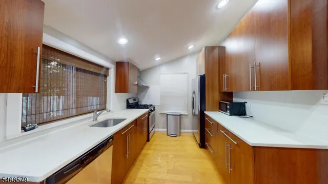 a large kitchen with a large window and stainless steel appliances