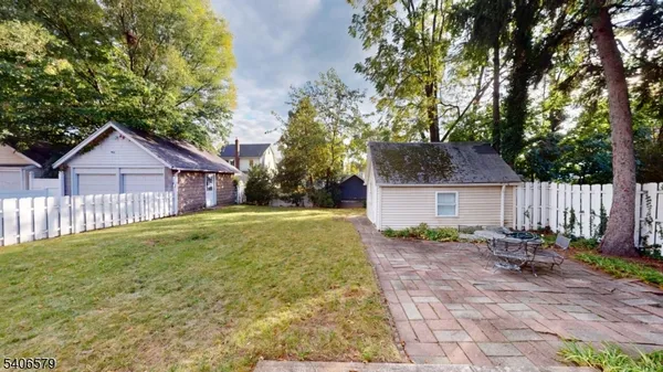 a view of a house with backyard and trees