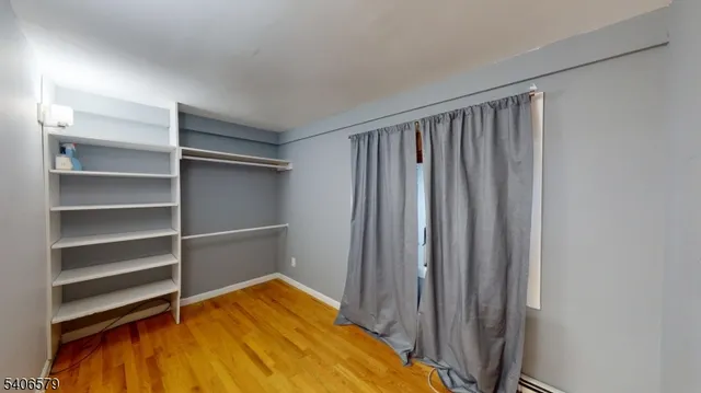 a view of a room with wooden floor and cabinet