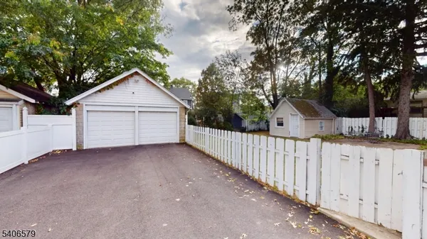 a view of house with wooden fence and trees