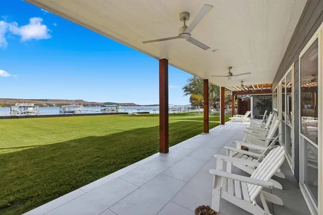 a living room with furniture kitchen view and large windows