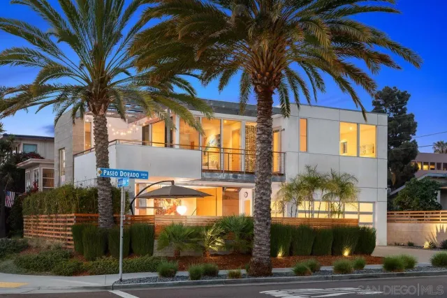 a view of a house with a yard and palm trees