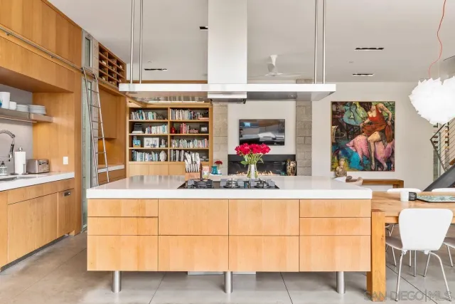a view of a patio with table and chairs potted plants and a barbeque
