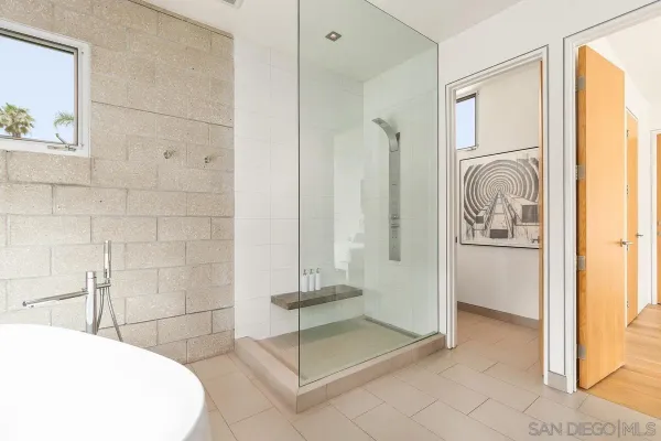 a spacious bedroom with a bed and glass window