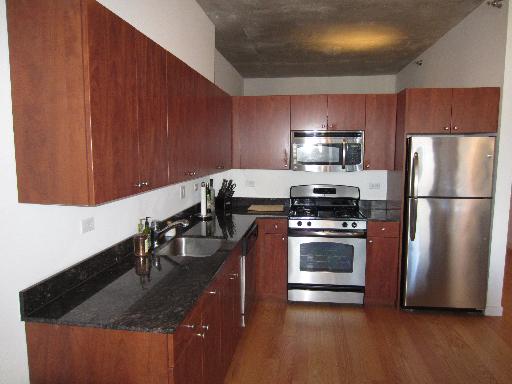 235 West Van Buren Street, Unit 3721 Chicago, IL 60607 - Photo 11 of 17 a kitchen with stainless steel appliances granite countertop a sink a stove and a refrigerator