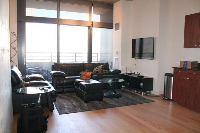 235 West Van Buren Street, Unit 3721 Chicago, IL 60607 - Photo 7 of 17 a living room with furniture window and a flat screen tv