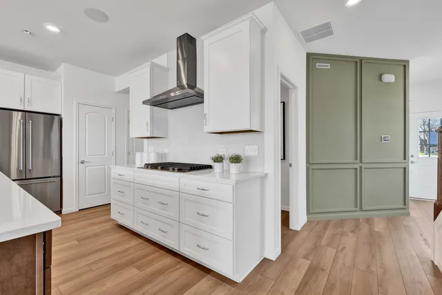 a kitchen with stainless steel appliances a stove a refrigerator and cabinets