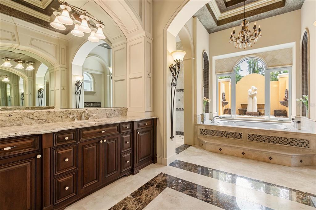 8590 Apache Trail Davenport, FL 33896 - Photo 44 of 100 a spacious bathroom with a granite countertop sink mirror and a bathtub