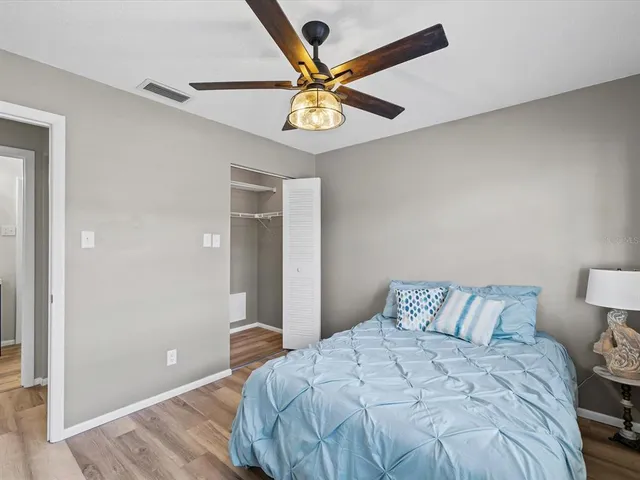 a bedroom with a bed and a ceiling fan