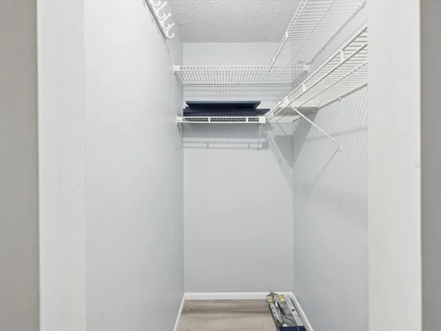 a view of walk in closet with empty racks