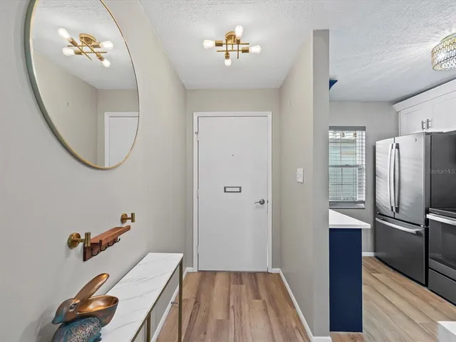 a view of a livingroom with wooden floor and a bathroom