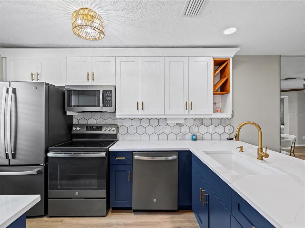 3717 Trophy Boulevard New Port Richey, FL 34655 - Photo 6 of 35 a kitchen with stainless steel appliances a stove cabinets and a sink