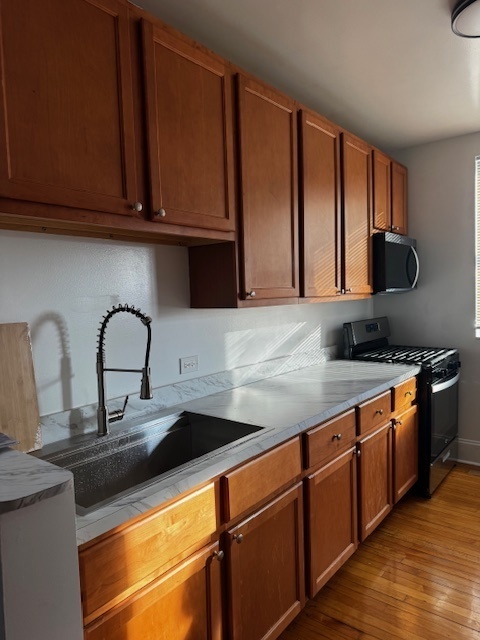 1614 North Harding Avenue, Unit 3E Chicago, IL 60647 - Photo 8 of 14 a kitchen with stainless steel appliances granite countertop a sink and cabinets