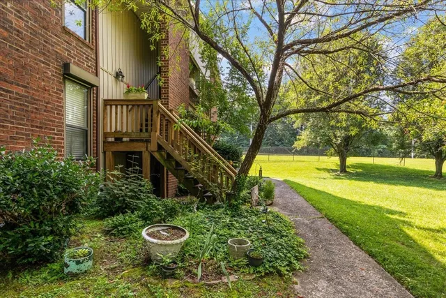 a view of a house with backyard and trees