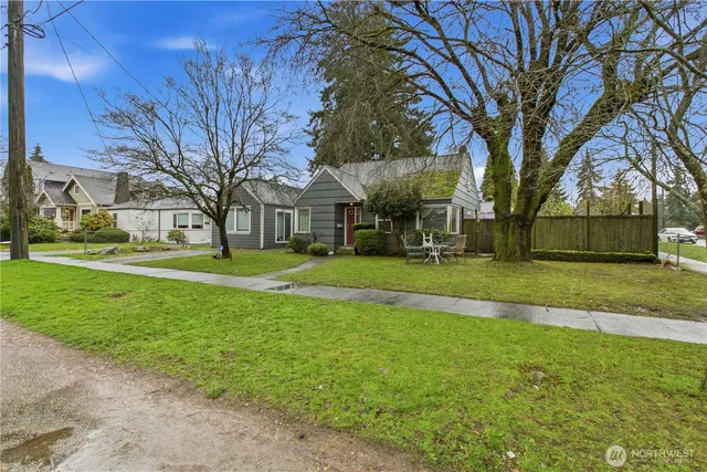 a view of a house with a big yard and large trees