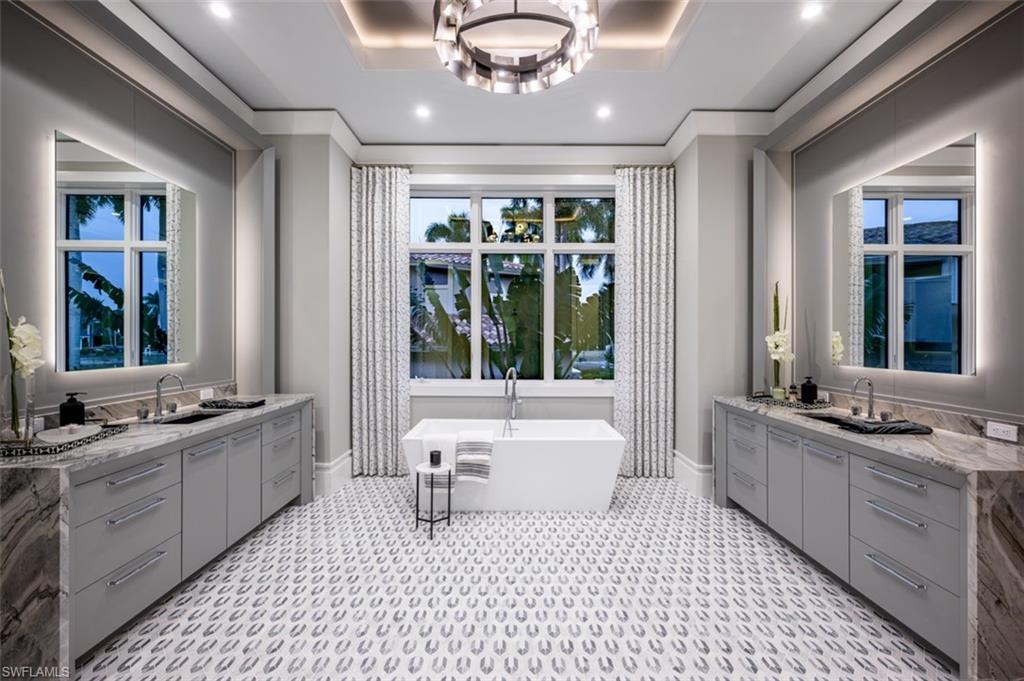 405 Neapolitan Way Naples, FL 34103 - Photo 20 of 50 a large bathroom with a large tub sink and window