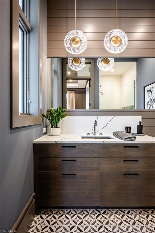 405 Neapolitan Way Naples, FL 34103 - Photo 25 of 50 a bathroom with a sink and a mirror