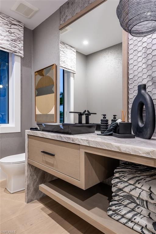 405 Neapolitan Way Naples, FL 34103 - Photo 27 of 50 a bathroom with a toilet a sink and mirror