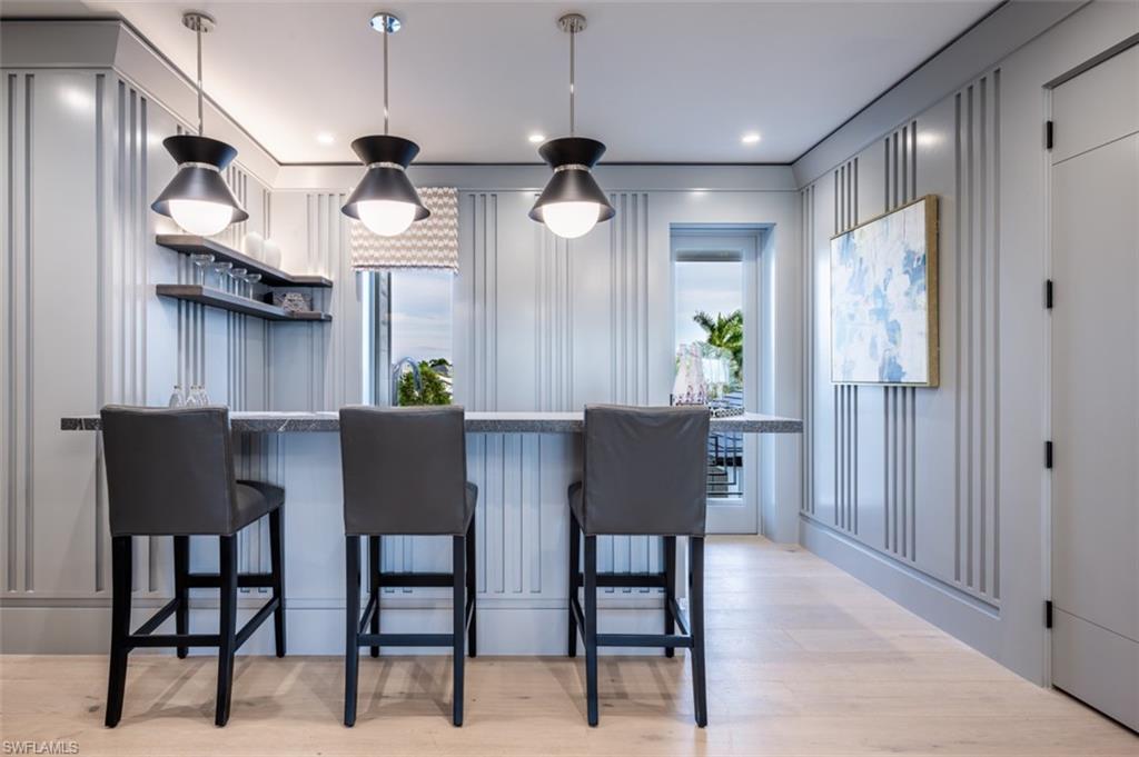 405 Neapolitan Way Naples, FL 34103 - Photo 29 of 50 a view of dining room and kitchen with furniture wooden floor and a chandelier