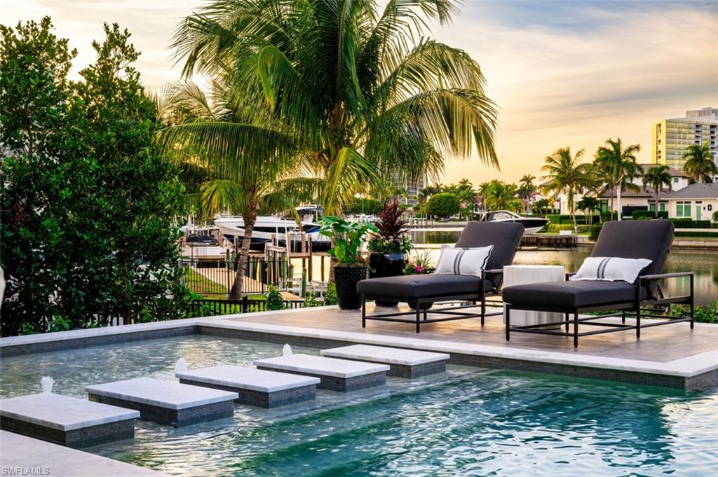 405 Neapolitan Way Naples, FL 34103 - Photo 40 of 50 a view of swimming pool with outdoor seating and plants