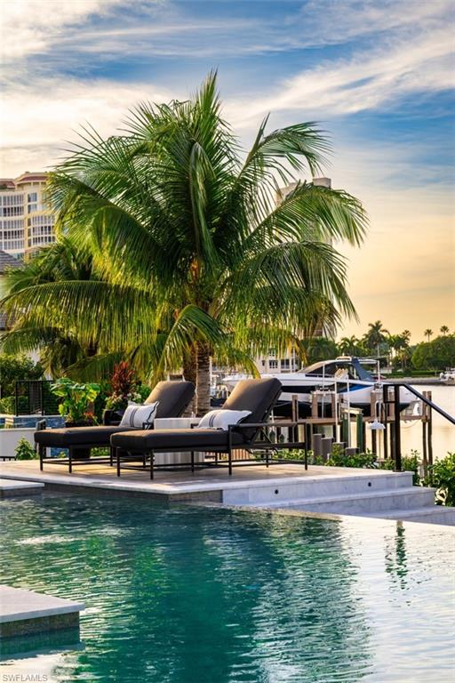 405 Neapolitan Way Naples, FL 34103 - Photo 41 of 50 a view of swimming pool with a table and chairs in patio