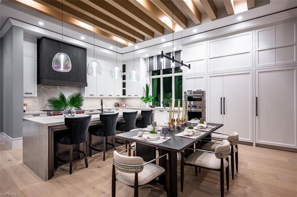 405 Neapolitan Way Naples, FL 34103 - Photo 8 of 50 a view of a dining room with furniture and wooden floor